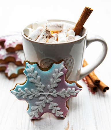Christmas cocoa, gingerbread cookies and decorations. White wooden background.