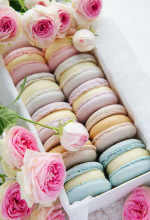 Colorful macaroons in a gift box and rosesの写真素材