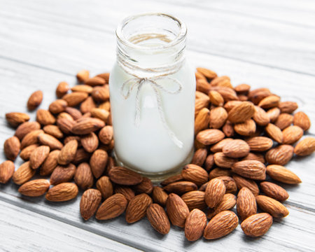 Almond milk with almonds on a wooden tableの写真素材
