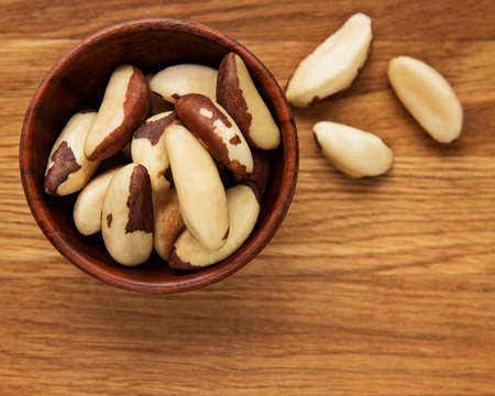 Bowl with Brazil nuts on wooden tableの写真素材
