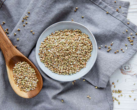 Organic green buckwheat on a white wooden tableの写真素材