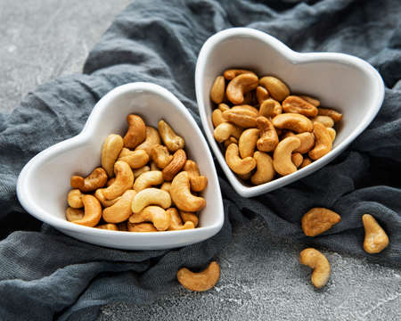Tasty cashew nuts in bowls on a gray concrete backgroundの写真素材