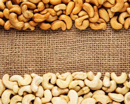 Tasty cashew nuts, raw and roasted on a burlap backgroundの写真素材