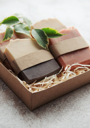 Assorted handmade soap bars and green leaves