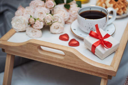 Romantic breakfast with coffee, waffles, gift box and rose flowers.の写真素材