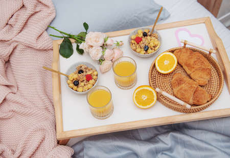 Romantic breakfast with croissants, orange juice and rose flowers.の写真素材