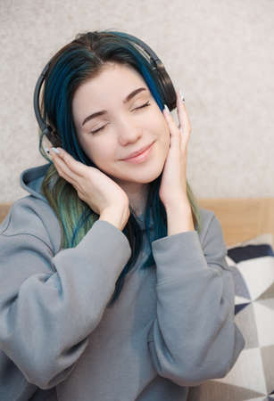 Young teenager girl with blue hair and headphonesの写真素材