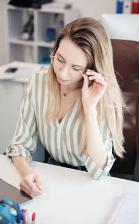 Young woman working on a computer in her officeの写真素材
