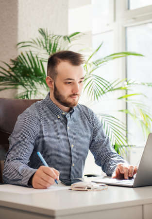 Young Businessman in shirt working on his laptop in an office