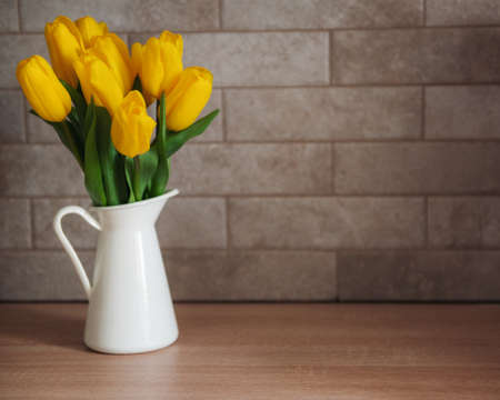 Beautiful yellow tulip flowers on table at kitchenの写真素材
