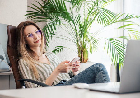 Young woman working on a computer in her officeの写真素材