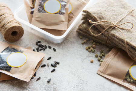 Microgreen seeds in paper bags and microgreen sowing equipment on the table. Health food.