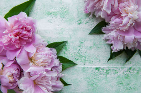 Floral frame with pink peonies. Pink flowers on a green wooden background. Copy space, top view. Mothers Day, Valentines Day, Birthday concept.の写真素材