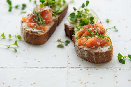 Sandwiches with salted salmon,  avocado and microgreens.  Healthy food.