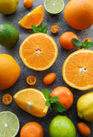 Sliced fresh citrus  on a dark concrete background. Healthy food.