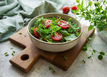 Vegan food: healthy fresh vegetables salad. Salad with arugula and cherry tomatoes.の写真素材