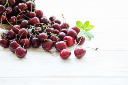 Fresh red cherries fruit on a white wooden background