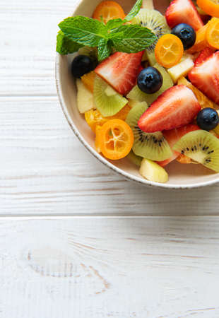 Healthy fresh fruit salad in a bowl on wooden backgroundの写真素材