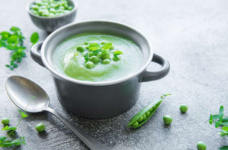 Fresh green pea soup bowl on gray concrete backgroundの写真素材