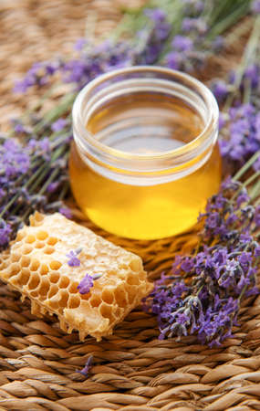 Glass of honey, honeycomb and lavender flowersの写真素材