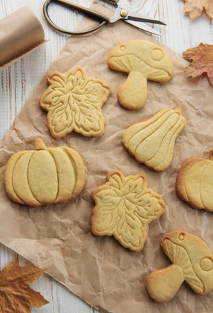 Autumn baking. Cookies in the form of pumpkin and leaves on the table. Cozy autumn concept.の写真素材