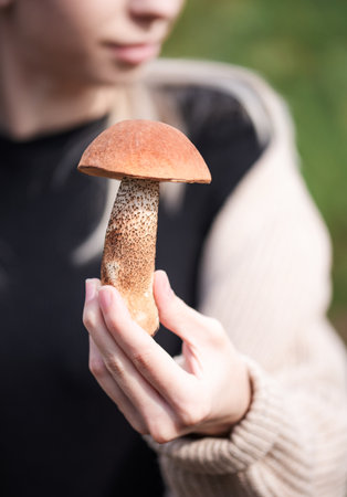 Woman holding freshly harvested edible porcini mushroomsの写真素材