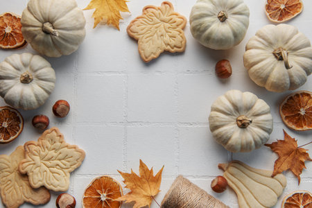 Autumn composition. Frame with pumpkins, dried leaves, cookies and nuts.  Autumn, fall, halloween, thanksgiving concept. Flat lay, top view, copy spaceの写真素材