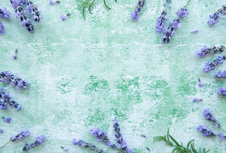 Lavender flowers and leaves creative frame on a green wooden background. Top view, flat lay. Floral...