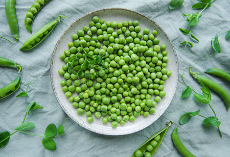 Bowl with young fresh juicy pods of green peas. Healthy organic food.