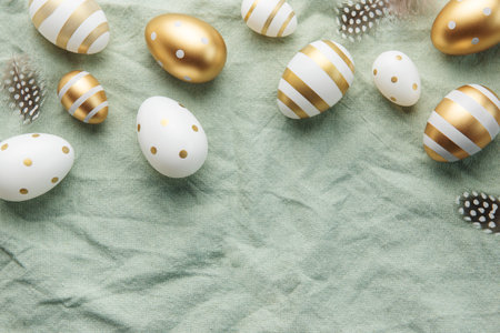 Easter eggs are painted with gold paint on a green linen background. Concept of Easter holidays....