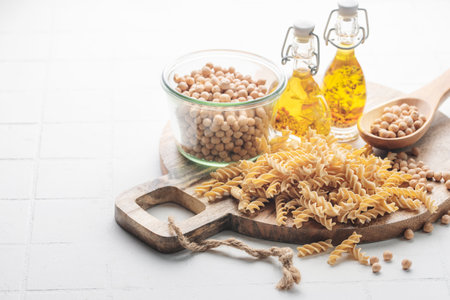 Chickpea bean fusilli pasta on a gray concrete background. Bowl with raw pasta and chickpea bean. Gluten free pasta.の写真素材