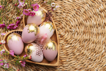 Easter decor. Easter eggs painted in gold in a heart-shaped wooden bowl. The concept of preparation...
