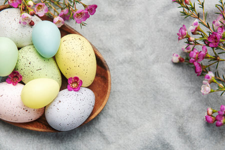 Easter decor. Colored Easter eggs on a wooden plate on the table. The concept of preparing for the...