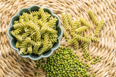 Mung bean fusilli pasta. Bowl with raw pasta and green mung bean. Gluten free pasta.の写真素材
