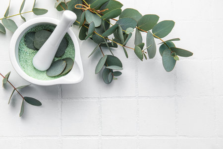 Massage and spa products salt with eucalyptus  on a white tile backgroundの写真素材