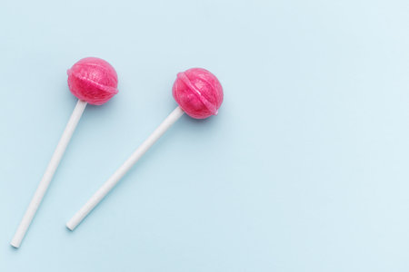 Colorful sweet lollipops over blue background.  Flat lay, top viewの写真素材