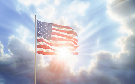 AI generative.  American Flag waving in the wind with the  blue sky background.  Flag day conceptの素材