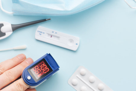 Pulse oximeter measuring oxygen saturation in blood and heart rate.  Pulse oximeter on the patient's handの写真素材