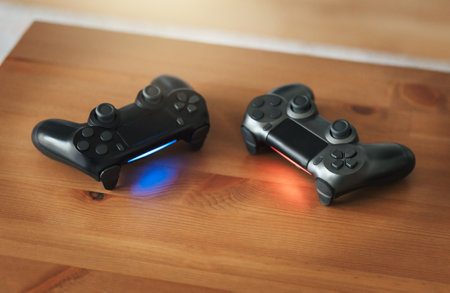 Video gaming consoles. Top view a gaming gear  on the table background. Joystick or gamepad on a...