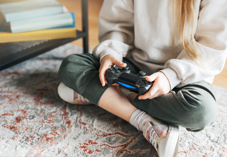 A little girl holding game controller playing video games