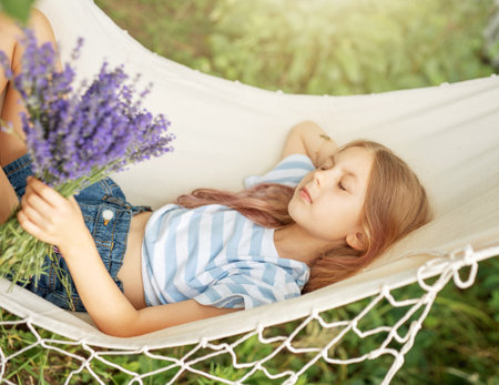 A little girl rests in a hammock  in the summer.  Summer in the village.の写真素材