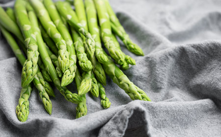 Fresh green asparagus on grey textile background. Flat layの写真素材