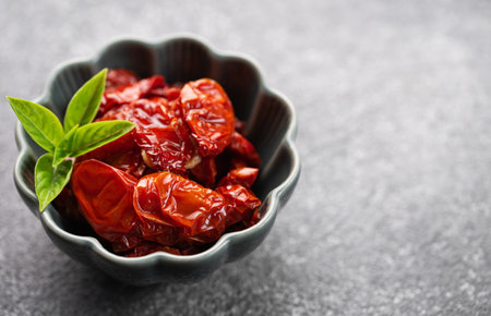Bowl with homemade sun dried tomatoes with fresh herbs and spices.の写真素材