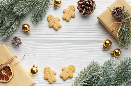 Christmas gifts, gingerbread cookies, decorations with christmas tree on white wooden background