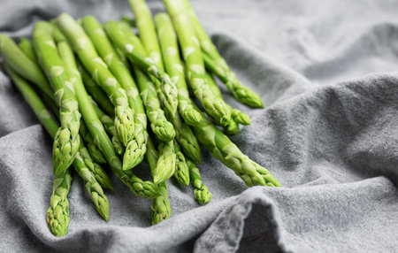 Fresh green asparagus on grey textile background. Flat layの写真素材