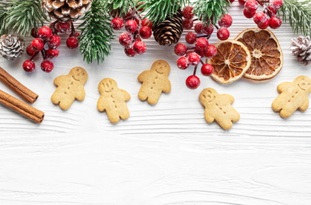 Christmas gifts, gingerbread cookies, decorations with christmas tree on white wooden background