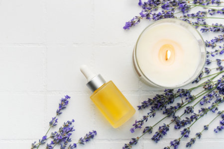 Lavender spa. Lavender  natural essential oil, aromatic candle and fresh lavender on a white tile background.の写真素材