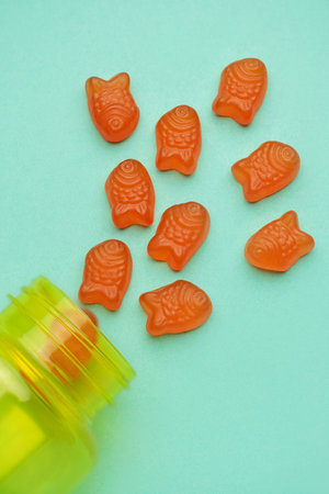 Vitamins for children,   jelly gummy fesh candy on pastel green  background
