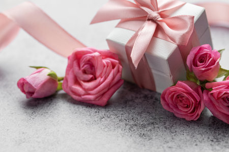Gift box and beautiful roses on concrete background. Valentines day conceptの写真素材