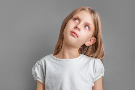 Portrait of a surprised little girl, girl with long blonde hair in white t-shirt
